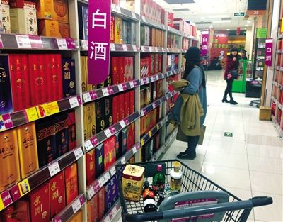 顧客在商場(chǎng)的高檔白酒貨架前駐足挑選。春節(jié)臨近，受“禁令”影響，以高檔白酒為代表的節(jié)日禮品市場(chǎng)面臨考驗(yàn)。記者 王遠(yuǎn)征 攝