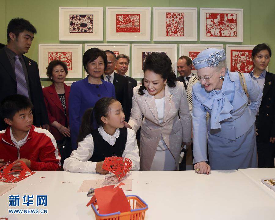 這是彭麗媛和瑪格麗特二世與根據(jù)安徒生童話中人物和情節(jié)制作剪紙的孩子交談。