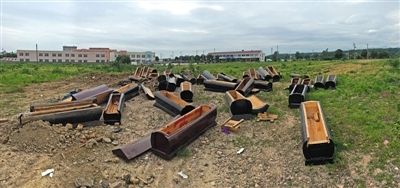 40多副棺木被砸壞后，扔在荒地上。