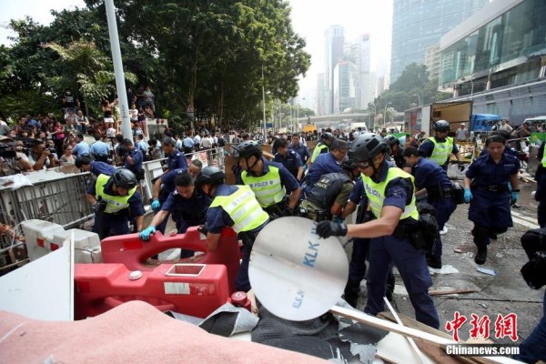 10月14日，警方清除金鐘道障礙物。大批警員在金鐘道現(xiàn)場(chǎng)清拆障礙物。部分警員戴上頭盔將障礙物移走。