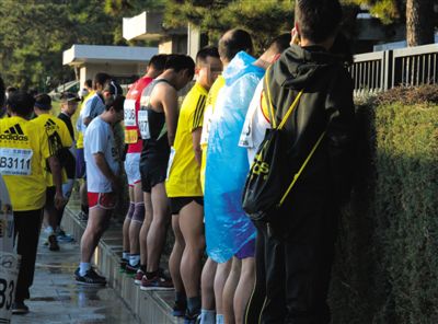 2013年10月20日，北京馬拉松比賽，由于廁位有限，一些選手在綠化帶“就地解決”。圖/IC