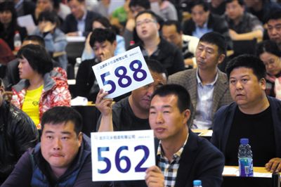 昨日，拍賣現(xiàn)場競拍者舉牌競拍。新京報記者
