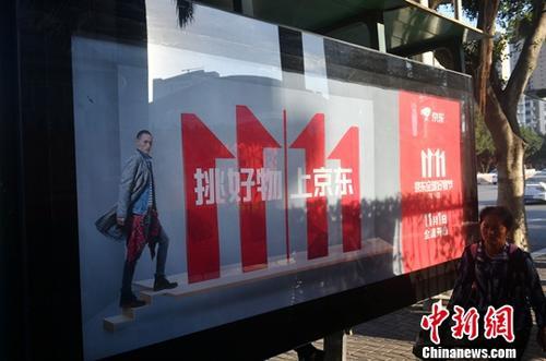 資料圖：11月1日，福州民眾從雙十一廣告牌前經(jīng)過。中新社記者 呂明 攝