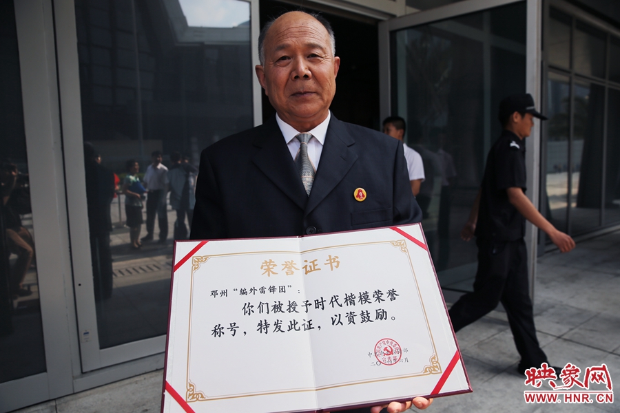 河南鄧州“編外雷鋒團(tuán)”團(tuán)長宋清梅向眾多記者展示中宣部授予的“時(shí)代楷?！睒s譽(yù)證書。