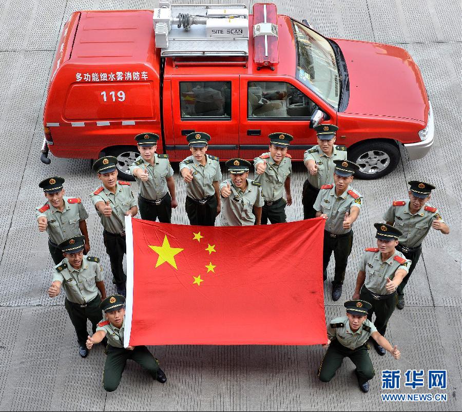  9月25日，武警浙江嘉興消防官兵與國旗合影。