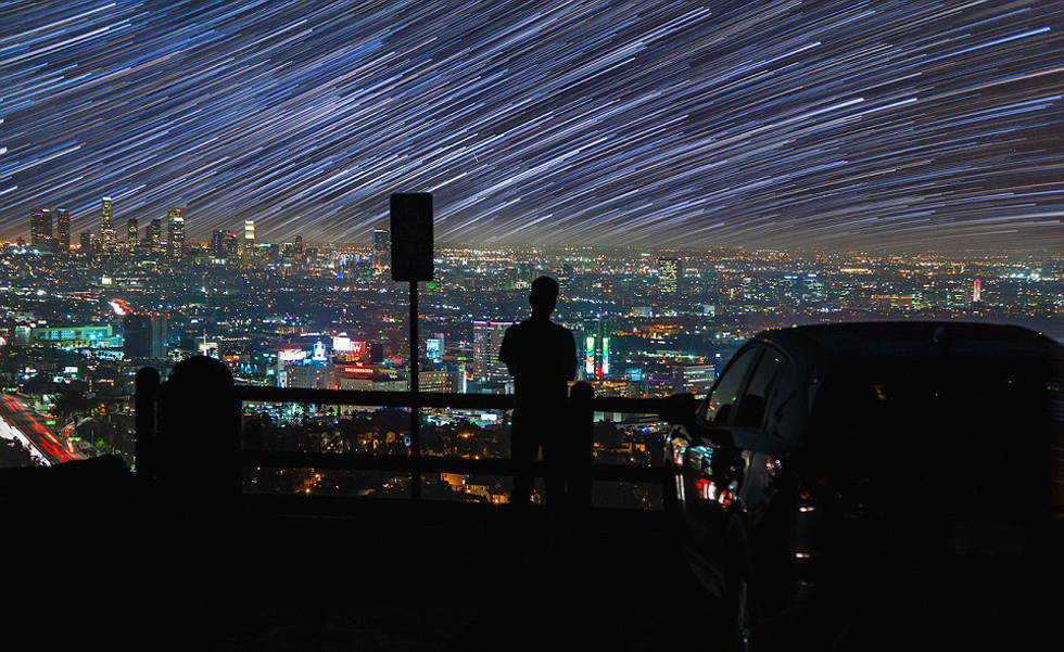照片中，一名男子看著流星和隕星劃過天空。（網(wǎng)頁截圖）
