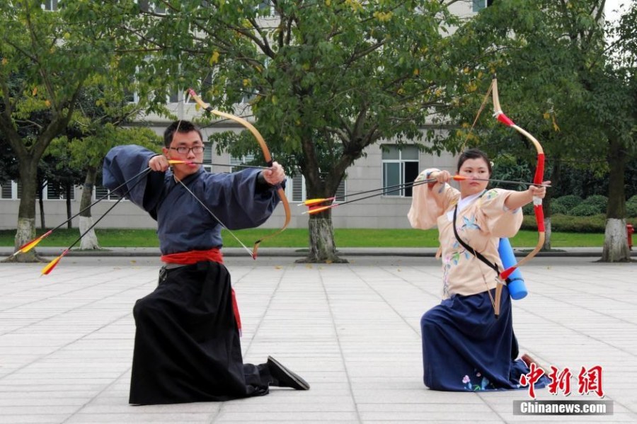 圖為課余練習射箭的“神雕俠侶”胡雅潔和胡默齋。