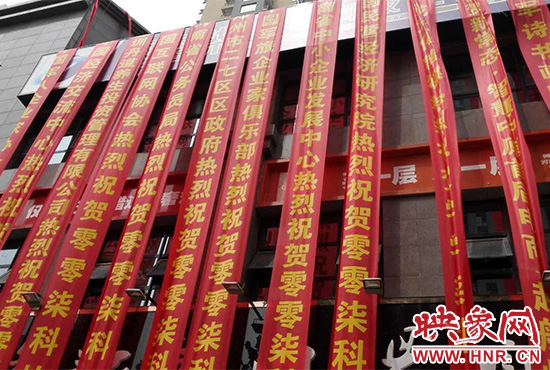 路邊一棟樓上懸掛著二三十條紅色條幅，全部是祝賀一家公司開(kāi)業(yè)的。