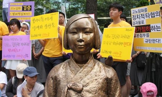 7月2日，在韓國首爾的日本駐韓國大使館前，民眾在慰安婦少女像旁手持標(biāo)語參加抗議活動。