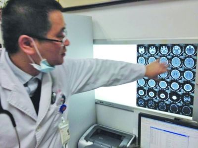 醫(yī)生在查看男孩的腦部CT片。薛馬義 攝