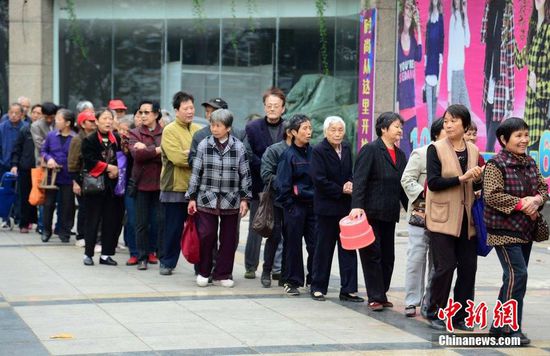 圖為10月28日，在江西九江市一家羊絨皮草服裝服飾博覽會(huì)現(xiàn)場(chǎng)，老人們正在頂著寒風(fēng)排隊(duì)等待領(lǐng)取10元代金劵。
