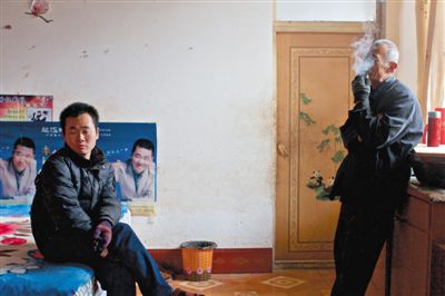 父親抽煙，兒子不語。逃跑的越南新娘，給袁迎賓父子帶來的是失落。新京報記者 周崗峰 攝