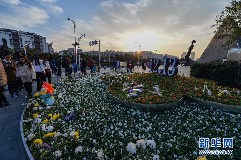 12月14日,觀眾在侵華日軍南京大屠殺遇難同胞紀(jì)念館前的“12·13”花壇上擺放鮮花祭奠遇難同胞。新華社記者 沈鵬 攝